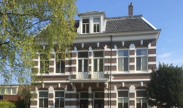 Gerenoveerde villa met witte speklagen en een dakkapel
