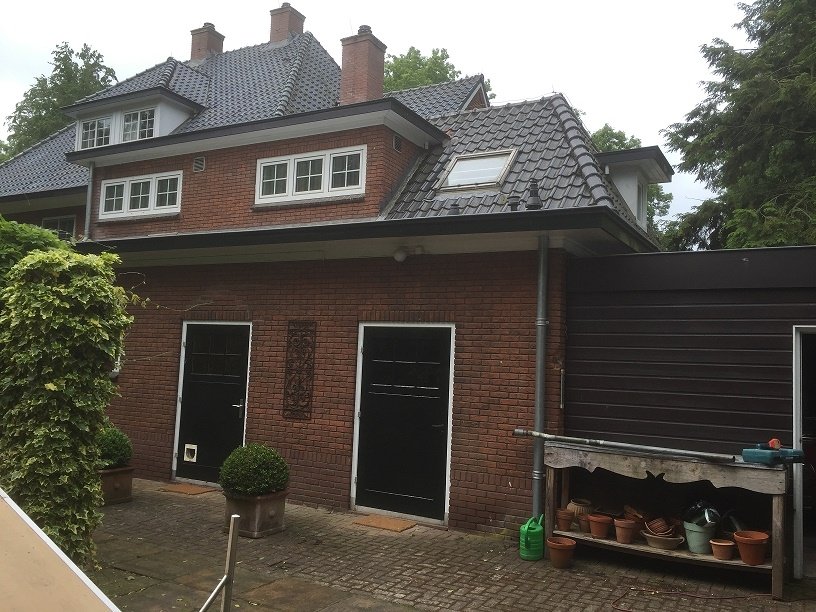 Gerenoveerde bakstenen woning met nieuwe zwarte deuren en dakkapel