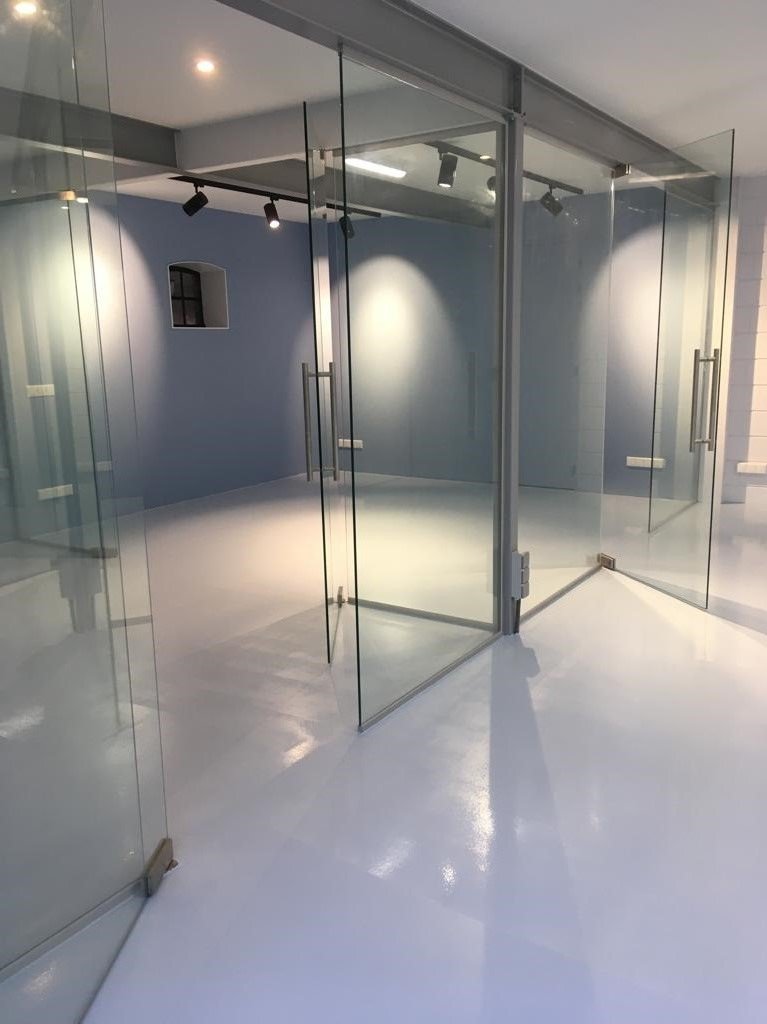 Atelier met glazen scheidingswanden en gietvloer